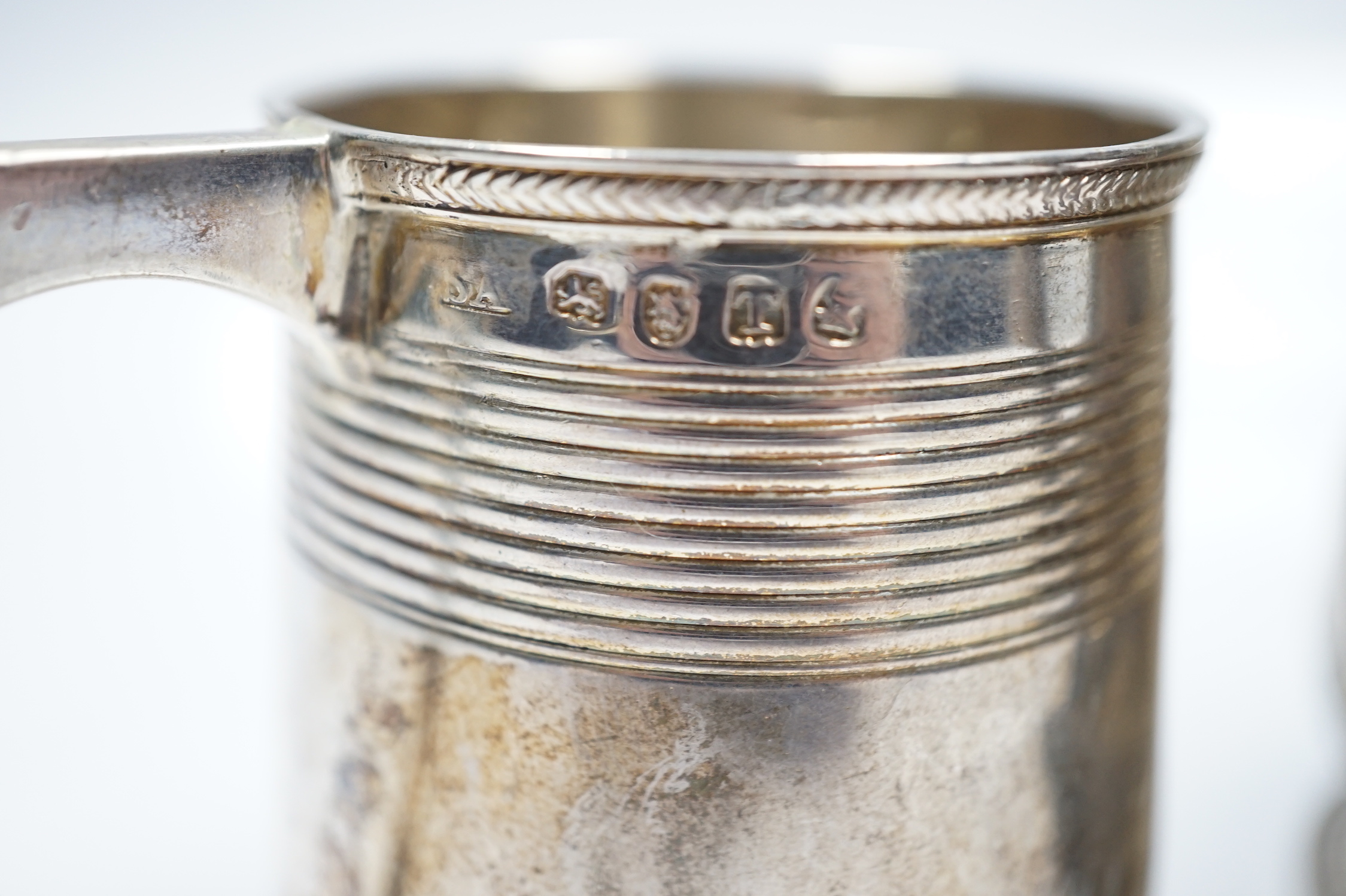 A late George II silver baluster mug, with later embossed decoration, William Shaw II?, London, 1756, 93mm, together with a George III reeded silver small christening mug, London, 1814.